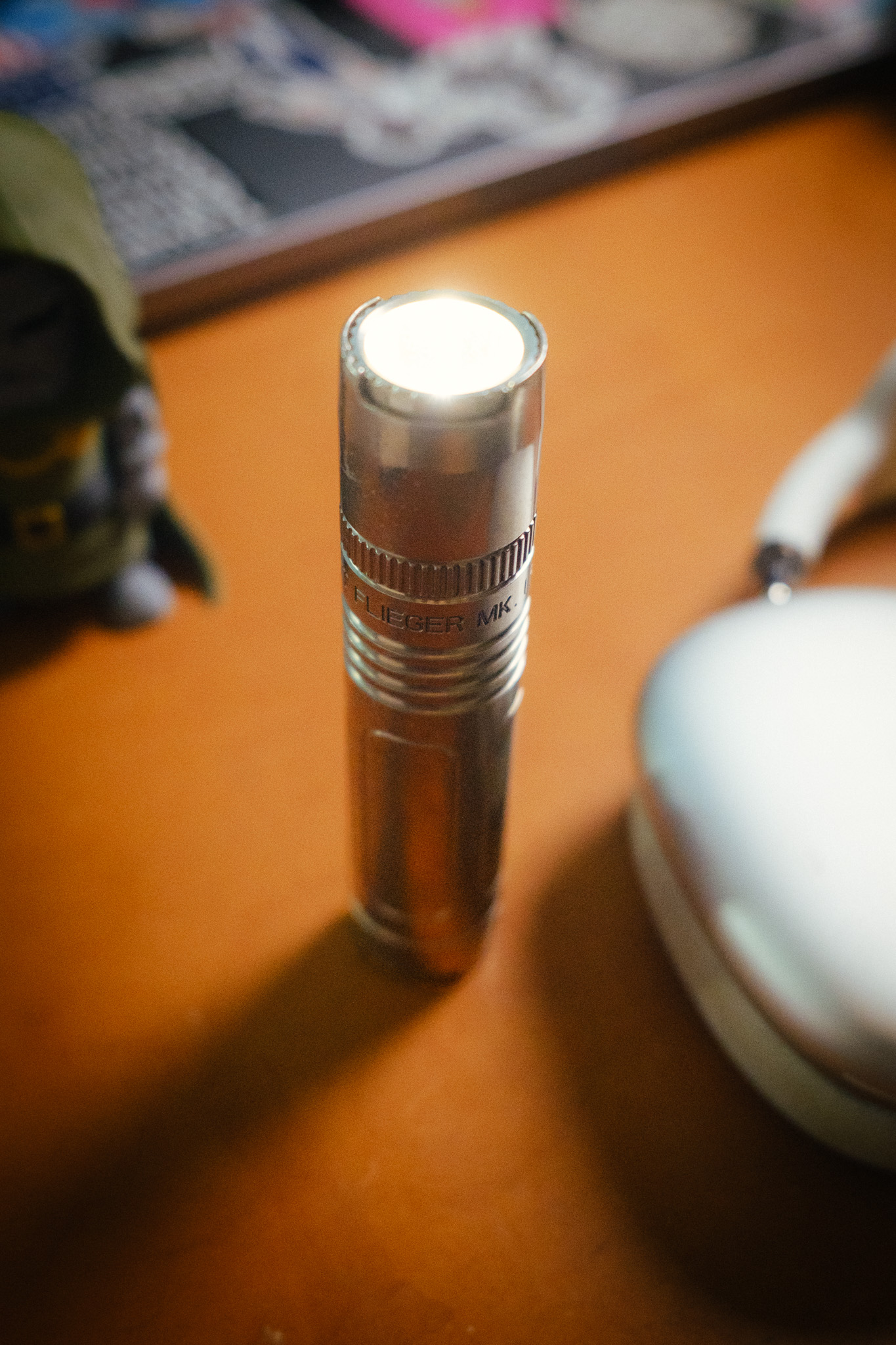 The flashlight standing upright, emitting light